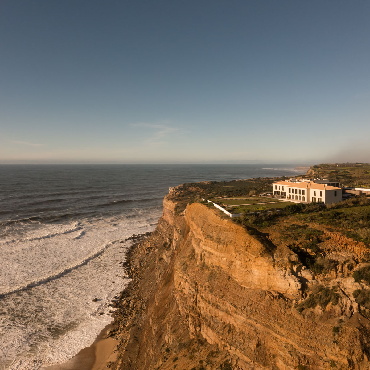 Aethos Ericeira Hotel - Overhead view of hotel facade and seaside cliffs
