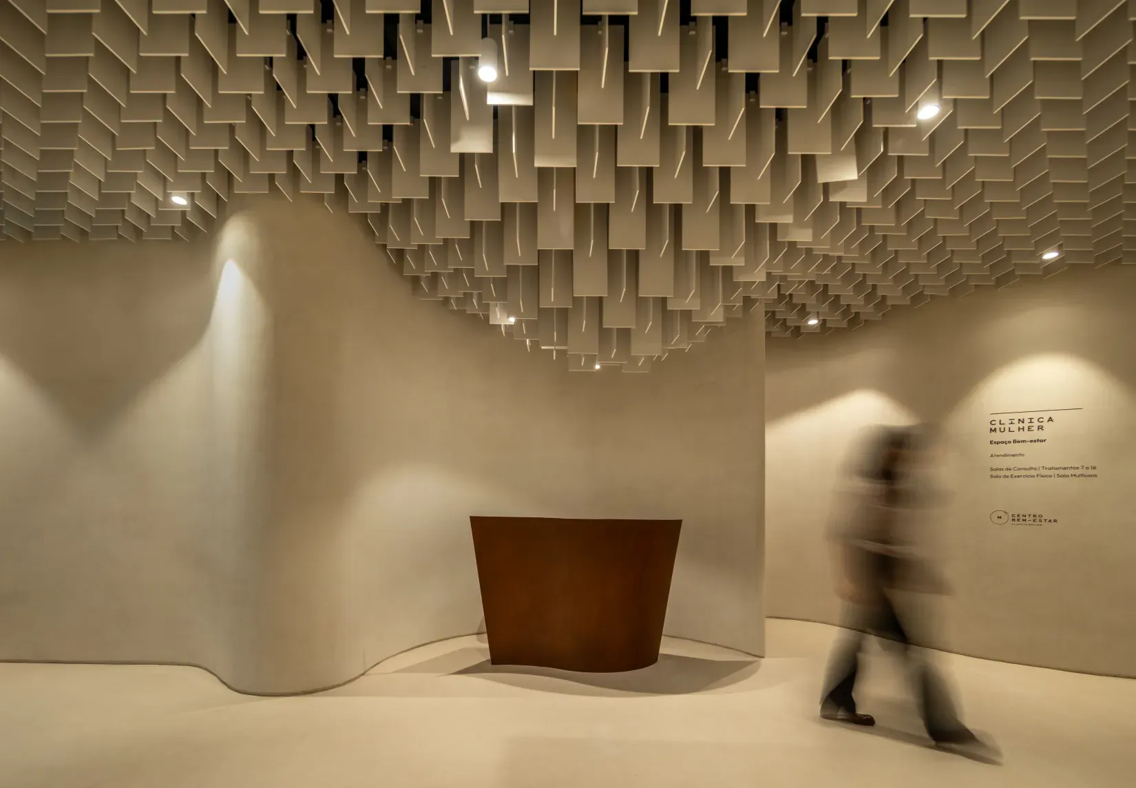 Clínica Mulher reception desk beneath the suspended slat ceiling