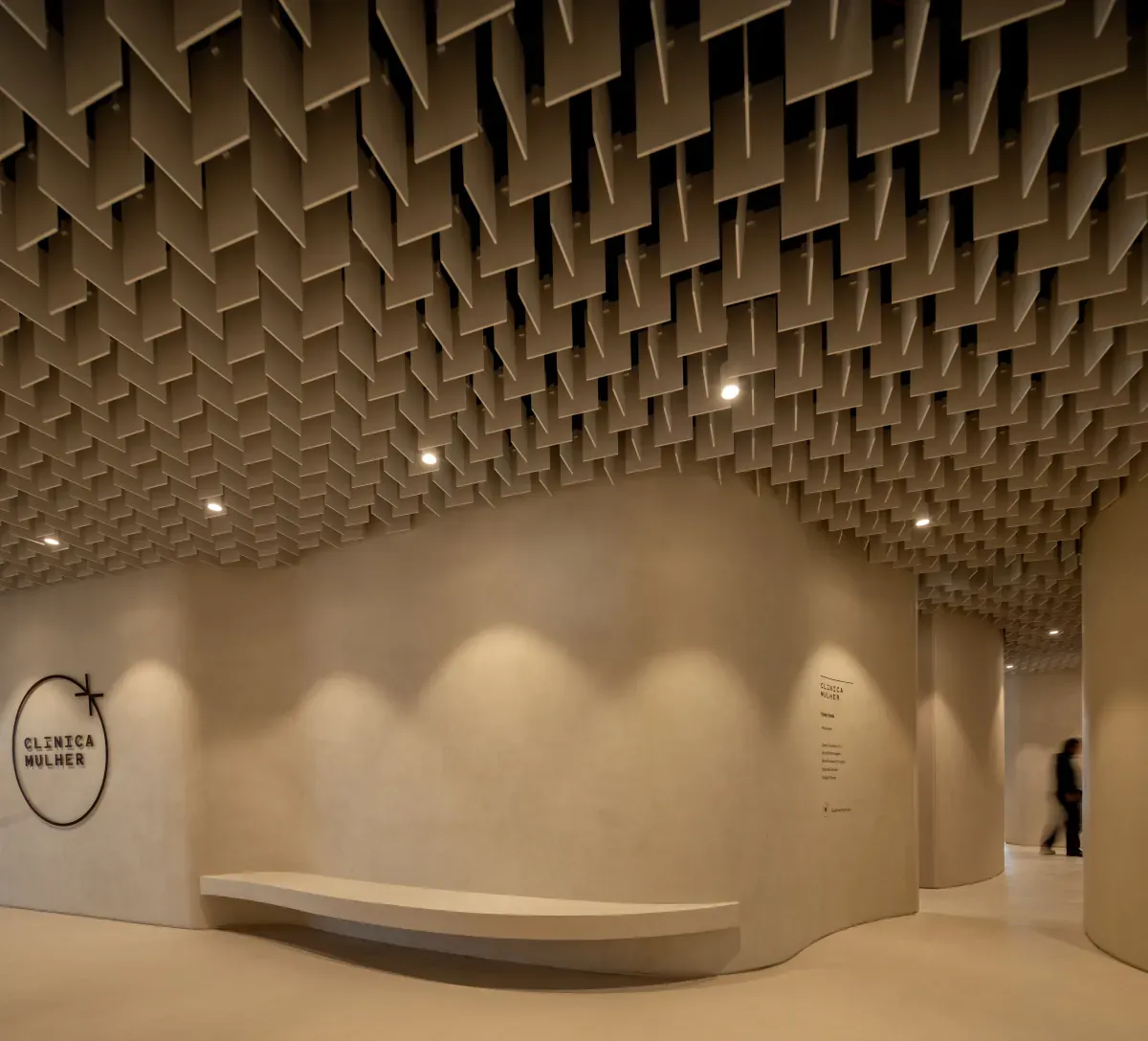 Clínica Mulher entrance with curved walls and waiting bench